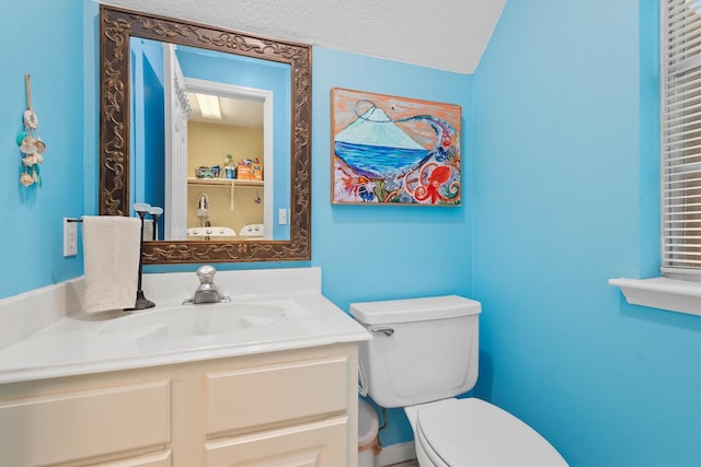 half bath featuring toilet, a textured ceiling, and vanity