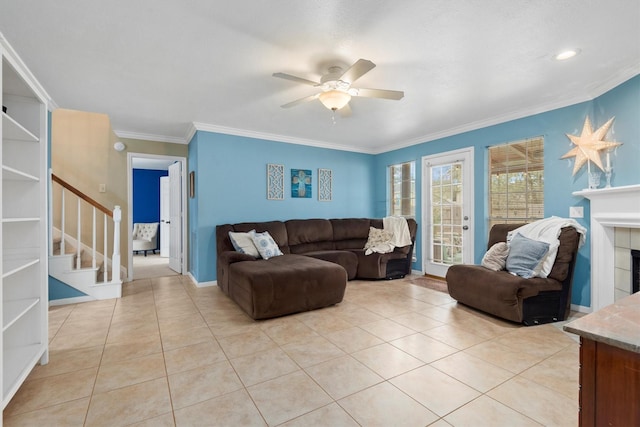 living room featuring stairs, crown molding, light tile patterned floors, and a ceiling fan