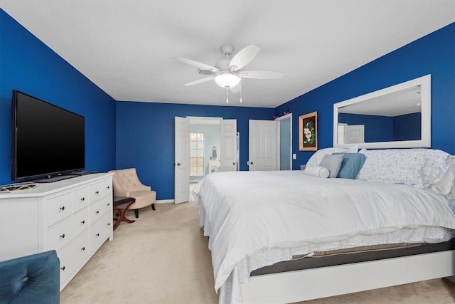 bedroom with baseboards, light carpet, ensuite bath, and ceiling fan