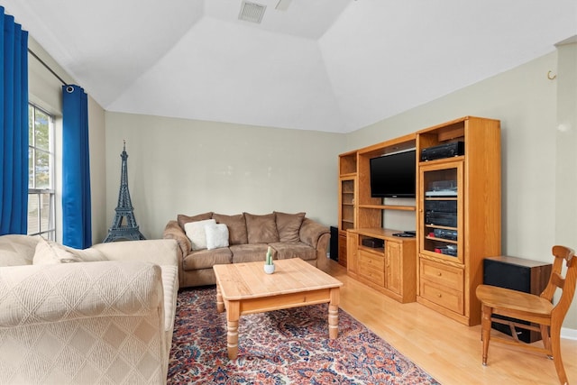 living room with visible vents, light wood-style floors, and lofted ceiling