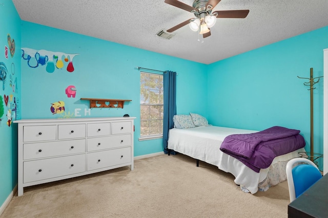 bedroom featuring visible vents, baseboards, carpet, a textured ceiling, and a ceiling fan