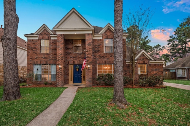 view of front of house with a yard and brick siding