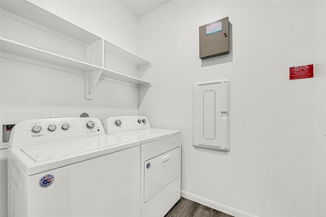 laundry area with washer and clothes dryer, electric panel, laundry area, baseboards, and dark wood-style flooring