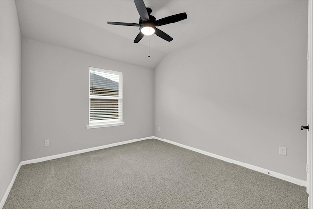 spare room with vaulted ceiling, carpet, baseboards, and ceiling fan