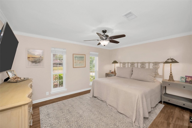 bedroom featuring visible vents, baseboards, dark wood-style floors, and ornamental molding