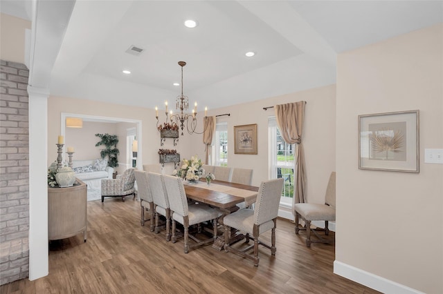 dining room featuring visible vents, wood finished floors, recessed lighting, an inviting chandelier, and a raised ceiling