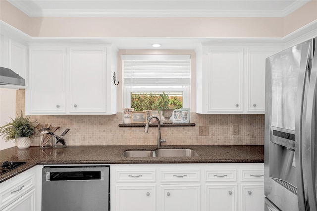 kitchen featuring a sink, backsplash, white cabinetry, stainless steel appliances, and dark stone counters