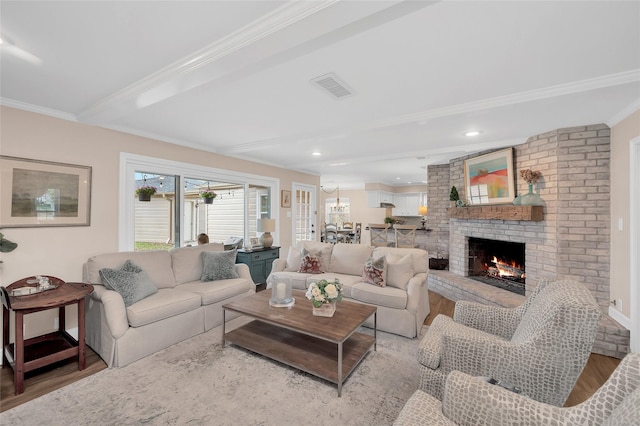 living area featuring wood finished floors, visible vents, recessed lighting, ornamental molding, and a brick fireplace