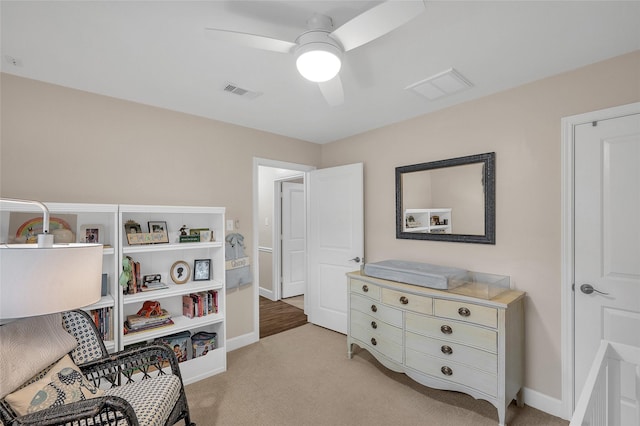 living area with light carpet, visible vents, and a ceiling fan