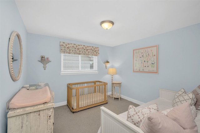 carpeted bedroom featuring a crib and baseboards