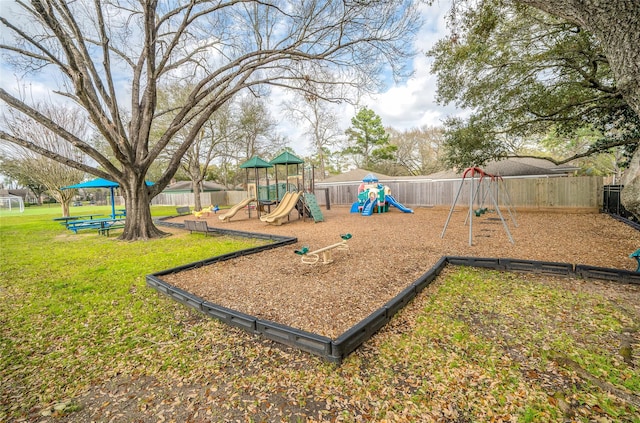 communal playground featuring a yard and fence