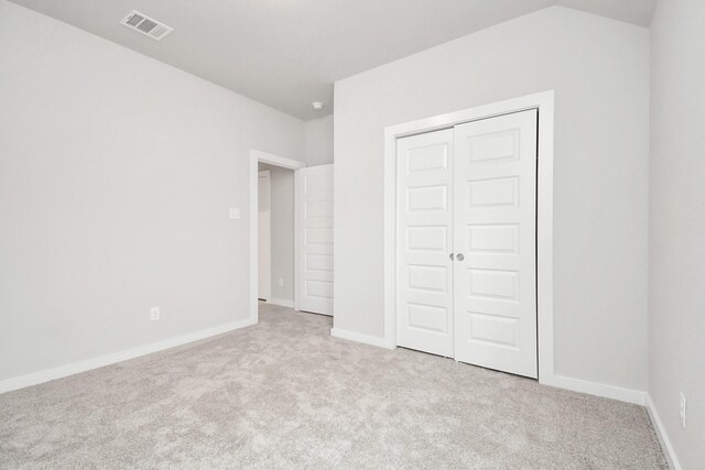 unfurnished bedroom featuring carpet flooring, baseboards, visible vents, and a closet