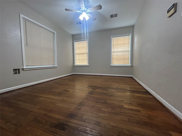 empty room with visible vents, baseboards, and wood finished floors