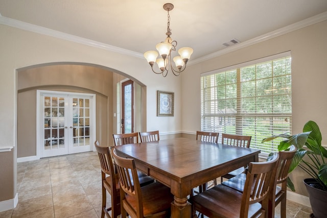 dining room featuring visible vents, arched walkways, ornamental molding, french doors, and a chandelier