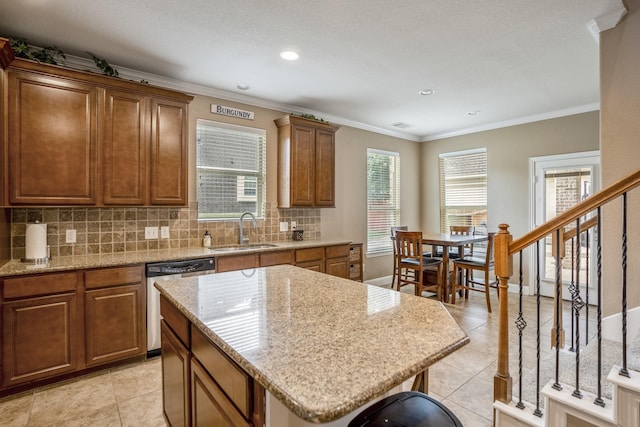 kitchen with light tile patterned flooring, ornamental molding, a sink, stainless steel dishwasher, and tasteful backsplash