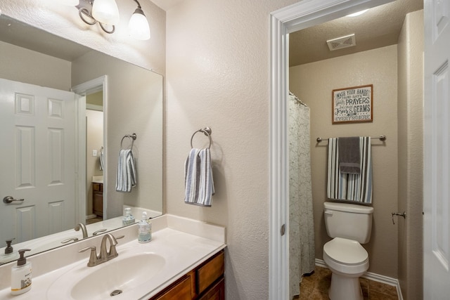 full bathroom featuring visible vents, toilet, a textured wall, tile patterned floors, and vanity