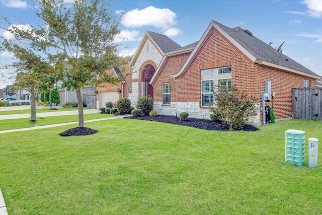 view of front of property with stone siding, brick siding, a front yard, and a shingled roof