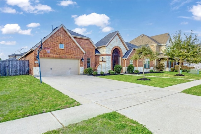 view of front of property featuring brick siding, fence, a front yard, stone siding, and driveway