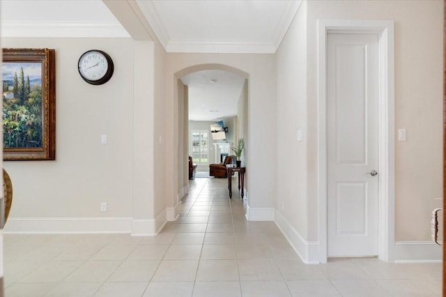 corridor featuring light tile patterned floors, baseboards, arched walkways, and ornamental molding