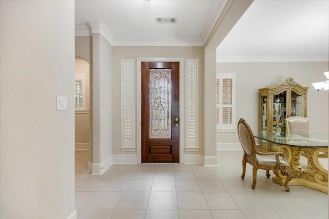 foyer entrance with visible vents, arched walkways, baseboards, and ornamental molding