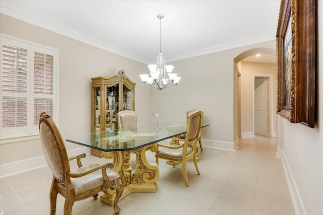 dining area featuring baseboards, arched walkways, an inviting chandelier, and ornamental molding