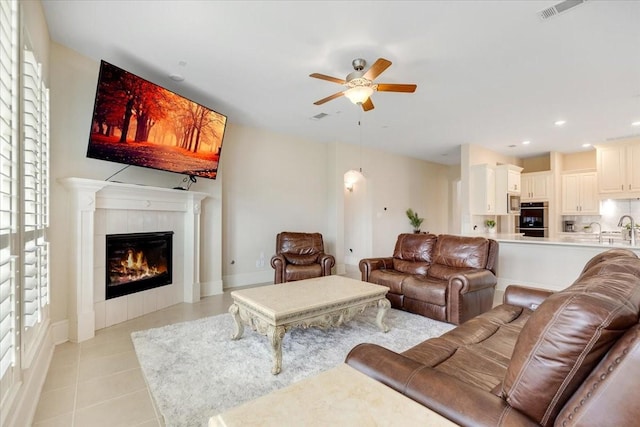 living area with visible vents, a ceiling fan, recessed lighting, a fireplace, and light tile patterned floors