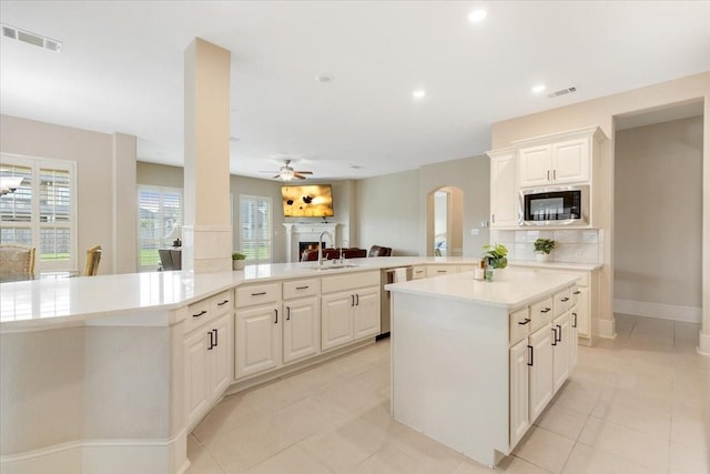 kitchen with visible vents, a center island, stainless steel appliances, light countertops, and ceiling fan