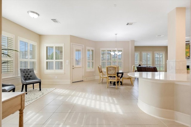 interior space with light tile patterned flooring, visible vents, and an inviting chandelier