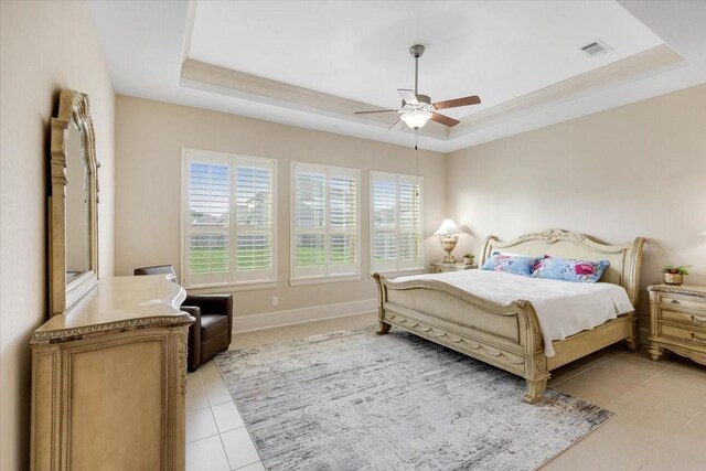 bedroom with baseboards, a raised ceiling, visible vents, and light tile patterned flooring