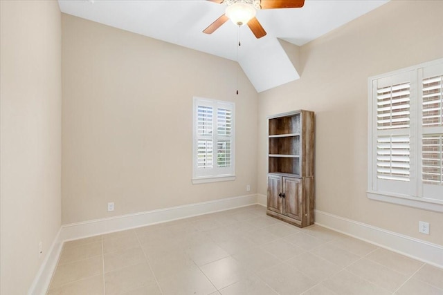 empty room with baseboards, lofted ceiling, ceiling fan, and light tile patterned flooring