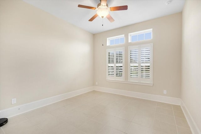 spare room with baseboards and a ceiling fan