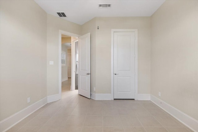 unfurnished bedroom with light tile patterned floors, visible vents, and baseboards