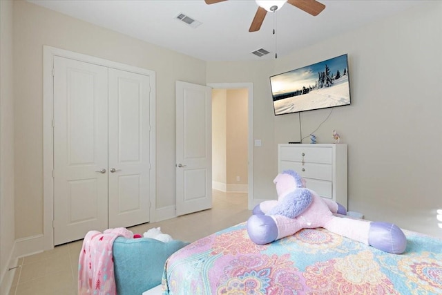 bedroom with visible vents, a closet, light tile patterned flooring, and a ceiling fan