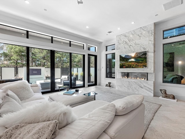 living area featuring a fireplace, recessed lighting, and visible vents