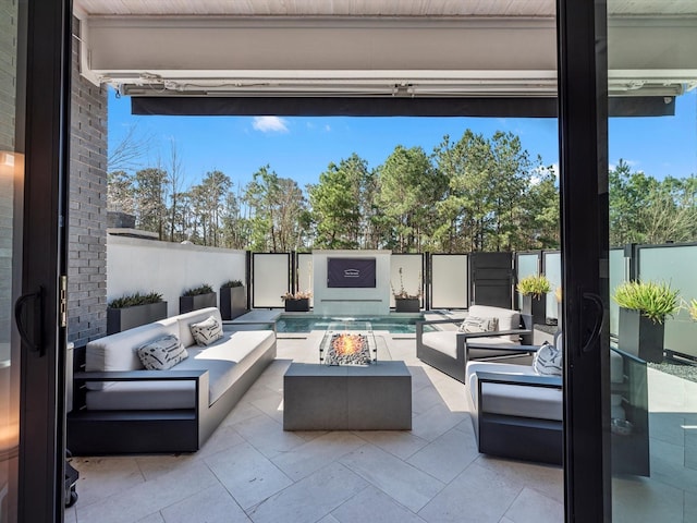 view of patio / terrace with an outdoor living space with a fire pit and a fenced backyard