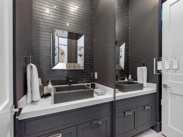 bathroom with a sink, tasteful backsplash, and double vanity