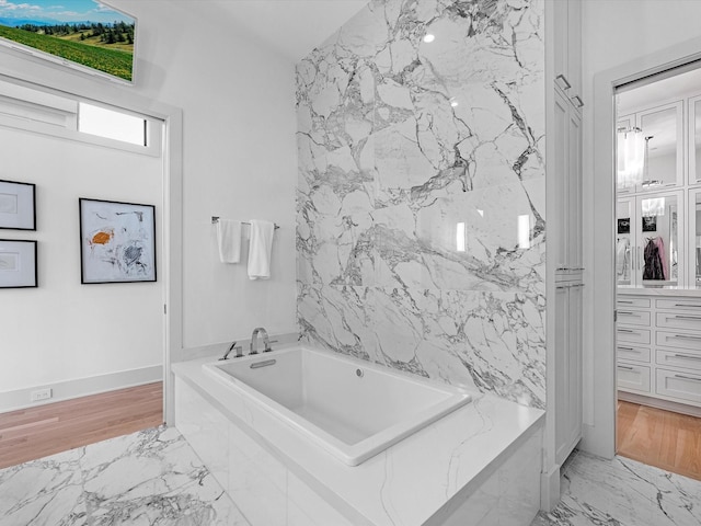 bathroom with a bath and marble finish floor