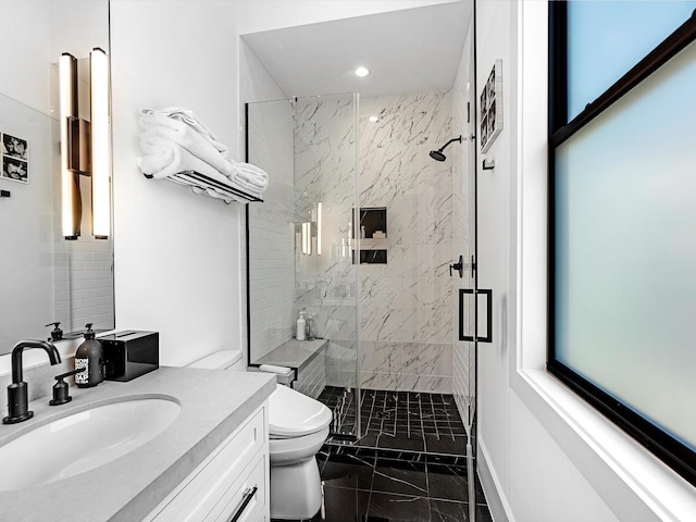 bathroom with vanity, toilet, marble finish floor, and a marble finish shower