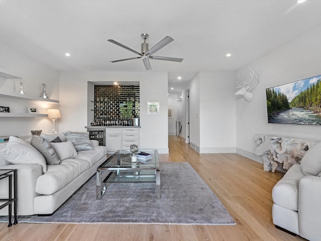 living area with ceiling fan, light wood-style floors, a dry bar, and recessed lighting