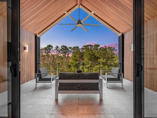 patio terrace at dusk featuring a balcony, ceiling fan, and outdoor lounge area