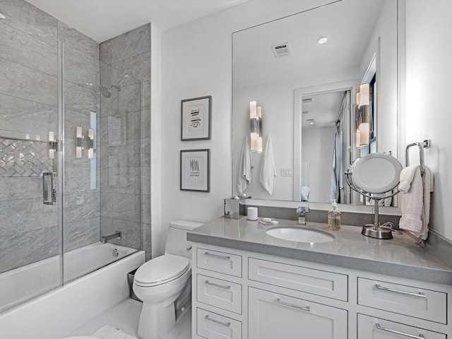 bathroom with visible vents, toilet, vanity, and shower / bath combination with glass door