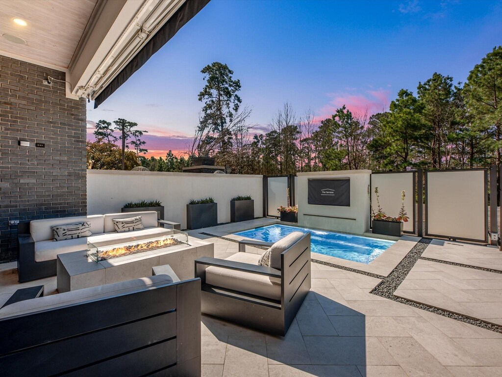 6406 Haskell St, Houston, TX 77007 - pool at dusk with a fenced in pool, a patio area, and an outdoor living space with a fire pit