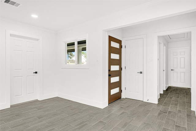 foyer featuring visible vents, wood finished floors, recessed lighting, crown molding, and baseboards