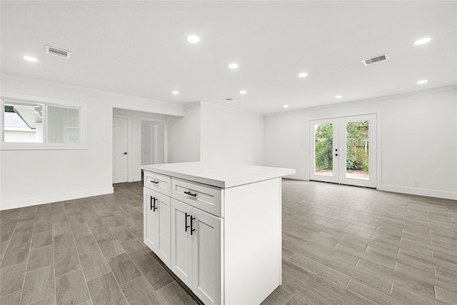 kitchen with wood finish floors, visible vents, and a center island