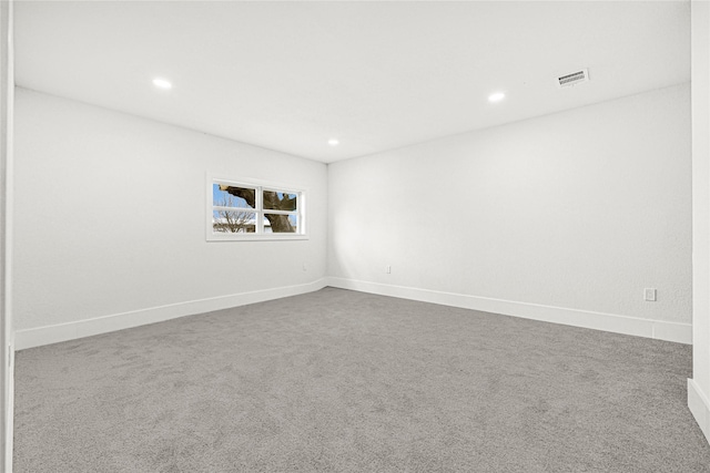 unfurnished room with recessed lighting, visible vents, dark carpet, and baseboards