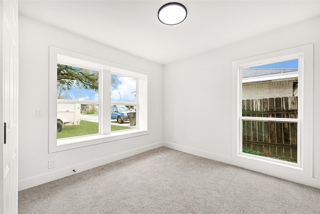 carpeted empty room featuring baseboards