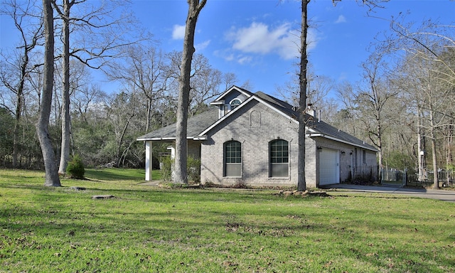 exterior space featuring a yard, driveway, brick siding, and an attached garage