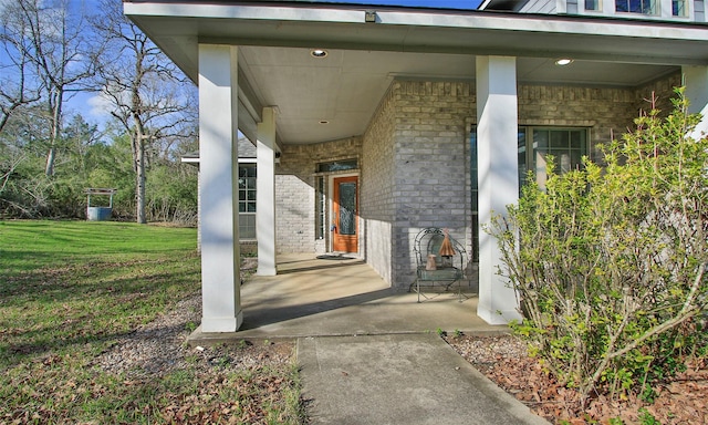 property entrance with a yard and brick siding