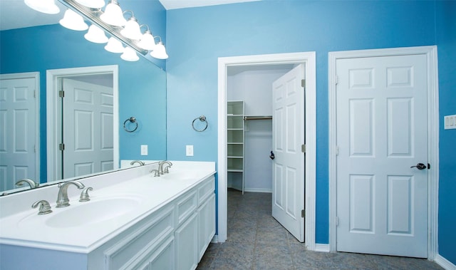 full bath with double vanity, baseboards, and a sink