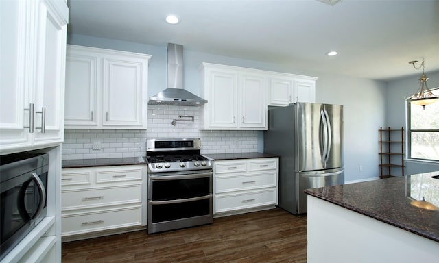 kitchen with tasteful backsplash, appliances with stainless steel finishes, dark wood-style floors, white cabinetry, and wall chimney exhaust hood